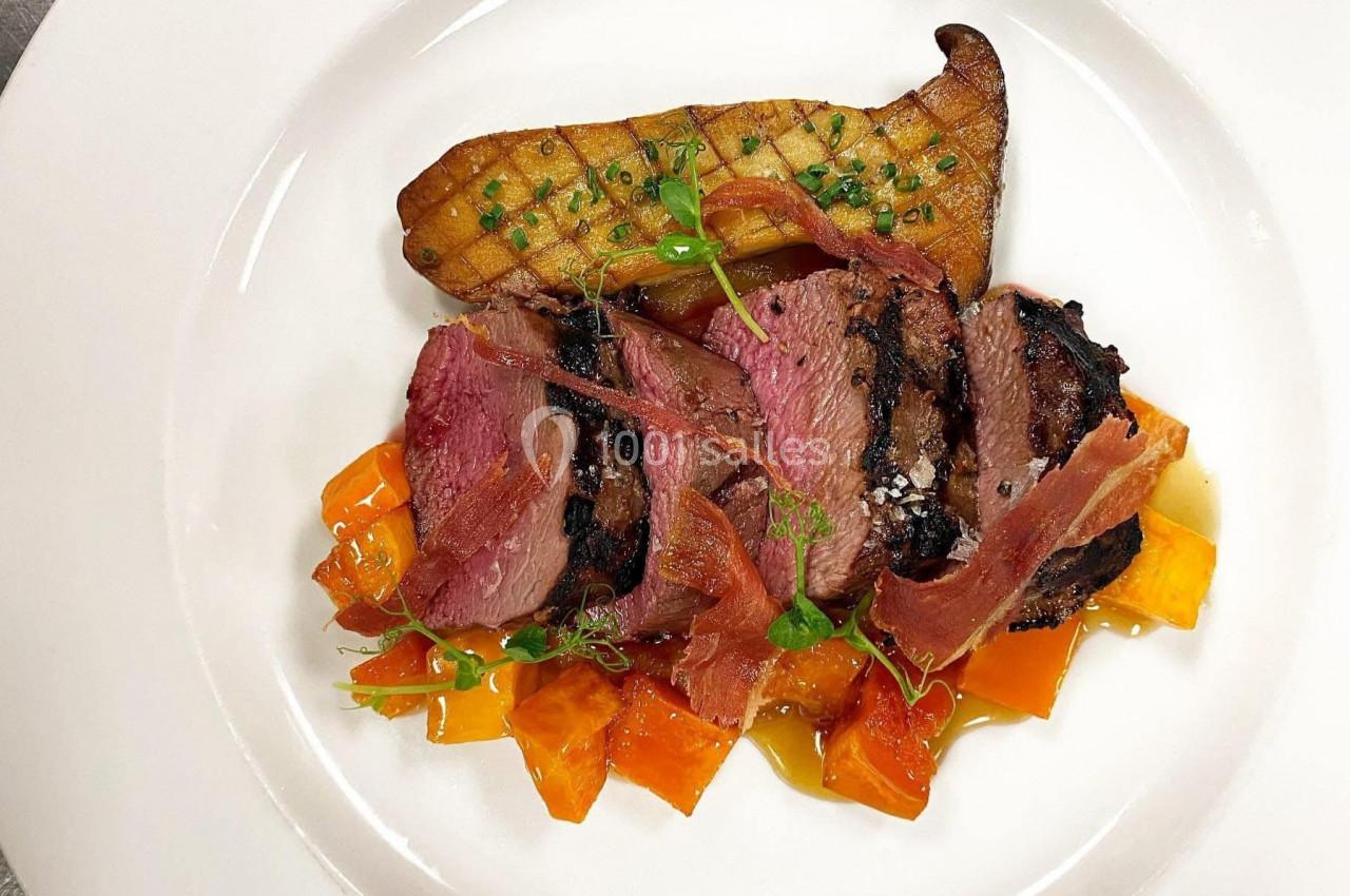 Assiette gastronomique avec magret de canard, patate douce, chips de jambon et garniture de poireau grillé.