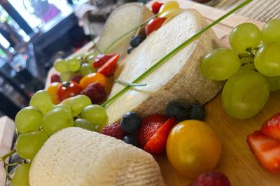 Assiettes composées de steaks grillés, purée, groseilles rouges, salade verte garnie de fleurs comestibles et sauce.