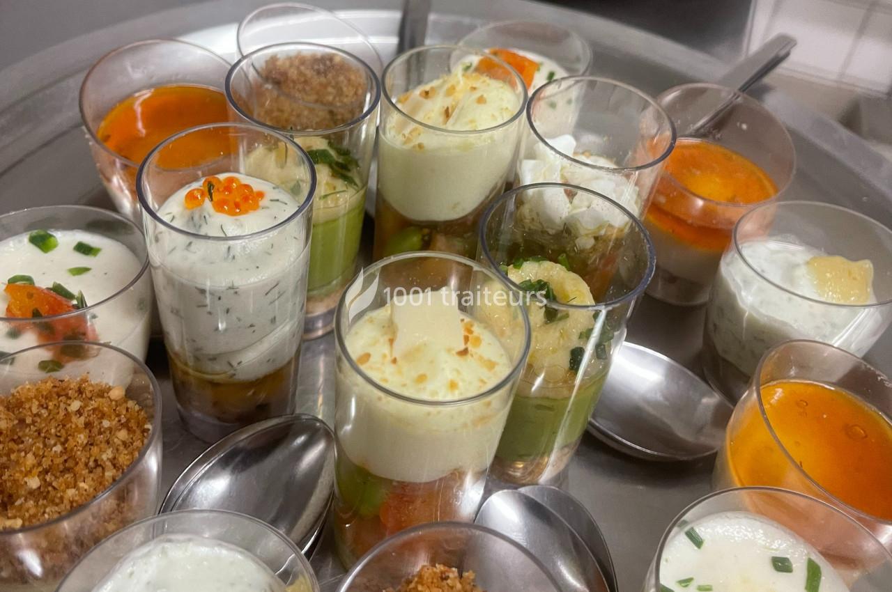 Assortiment de verrines salées variées présentées sur un plateau avec des cuillères.