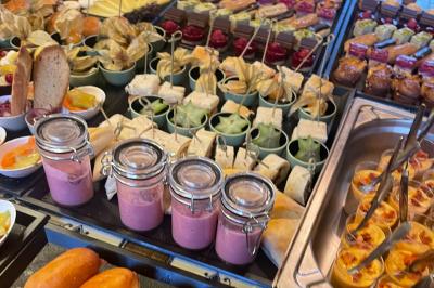 Assiettes composées de steaks grillés, purée, groseilles rouges, salade verte garnie de fleurs comestibles et sauce.