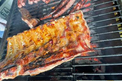 Assiettes composées de steaks grillés, purée, groseilles rouges, salade verte garnie de fleurs comestibles et sauce.