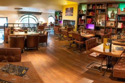 Pizza garnie de roquette, tomates cerises et légumes grillés, servie dans une assiette sur une table en marbre.