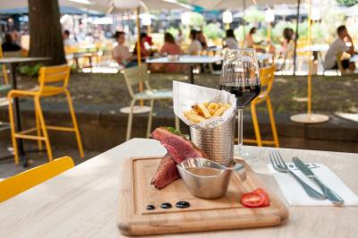 Pizza garnie de roquette, tomates cerises et légumes grillés, servie dans une assiette sur une table en marbre.