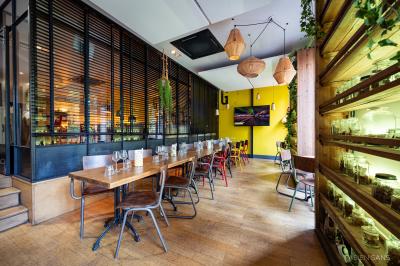 Pizza garnie de roquette, tomates cerises et légumes grillés, servie dans une assiette sur une table en marbre.