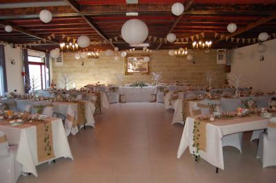 Cuisine professionnelle avec carrelage beige, plans de travail en inox, évier, réfrigérateur et éclairage fluorescent.