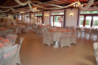 Cuisine professionnelle avec carrelage beige, plans de travail en inox, évier, réfrigérateur et éclairage fluorescent.