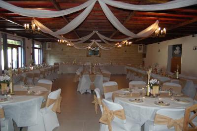 Cuisine professionnelle avec carrelage beige, plans de travail en inox, évier, réfrigérateur et éclairage fluorescent.