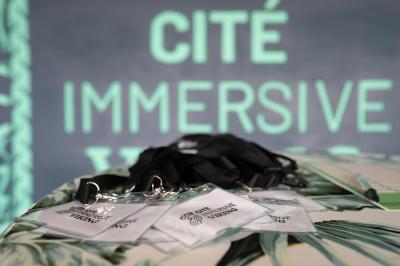 Une danseuse en tenue noire effectue une pose gracieuse sur une scène éclairée, devant un public attentif.