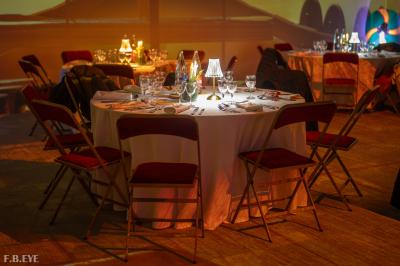 Une danseuse en tenue noire effectue une pose gracieuse sur une scène éclairée, devant un public attentif.