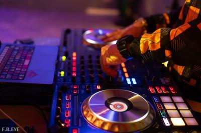 Une danseuse en tenue noire effectue une pose gracieuse sur une scène éclairée, devant un public attentif.