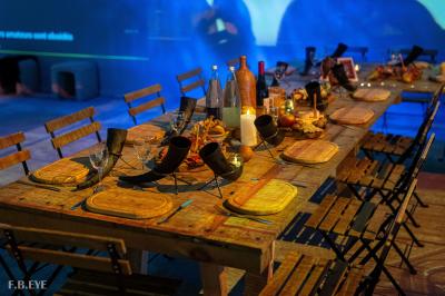 Une danseuse en tenue noire effectue une pose gracieuse sur une scène éclairée, devant un public attentif.