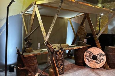 Une danseuse en tenue noire effectue une pose gracieuse sur une scène éclairée, devant un public attentif.