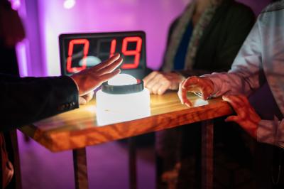 Une danseuse en tenue noire effectue une pose gracieuse sur une scène éclairée, devant un public attentif.