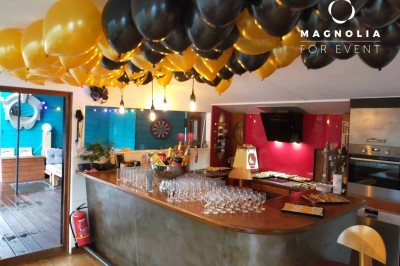 Miniature Location salle Boulogne-Billancourt (Hauts-de-Seine) - Le Loft Flottant de Nicolas #9 Ballons noirs et jaunes décorant un bar intérieur avec des verres alignés et un buffet en arrière-plan.