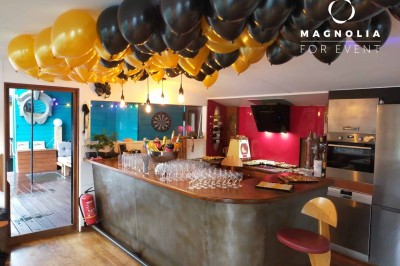 Miniature Location salle Boulogne-Billancourt (Hauts-de-Seine) - Le Loft Flottant de Nicolas #12 Ballons noirs et jaunes décorant un bar intérieur avec des verres alignés et un buffet en arrière-plan.