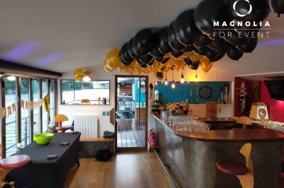 Miniature Location salle Boulogne-Billancourt (Hauts-de-Seine) - Le Loft Flottant de Nicolas #3 Ballons noirs et jaunes décorant un bar intérieur avec des verres alignés et un buffet en arrière-plan.