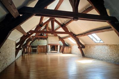 Table recouverte d'une nappe verte entourée de petites chaises colorées dans une pièce aux murs rouges et blancs.