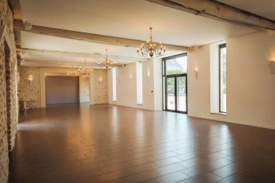 Table recouverte d'une nappe verte entourée de petites chaises colorées dans une pièce aux murs rouges et blancs.