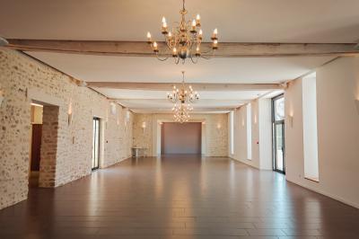 Table recouverte d'une nappe verte entourée de petites chaises colorées dans une pièce aux murs rouges et blancs.