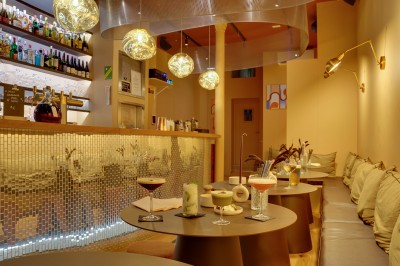 Tartines garnies de fromage frais, cubes de courge rôtie et graines, servies sur une table avec un verre d'eau.