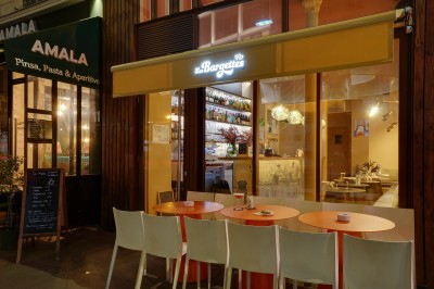 Tartines garnies de fromage frais, cubes de courge rôtie et graines, servies sur une table avec un verre d'eau.