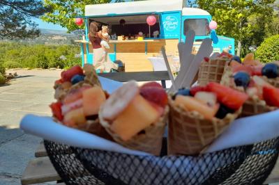 Buffet de salades avec légumes frais, noix, pain tranché et condiments, présenté en extérieur sur une table.