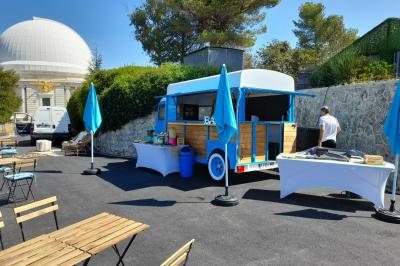Buffet de salades avec légumes frais, noix, pain tranché et condiments, présenté en extérieur sur une table.