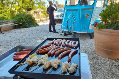 Buffet de salades avec légumes frais, noix, pain tranché et condiments, présenté en extérieur sur une table.
