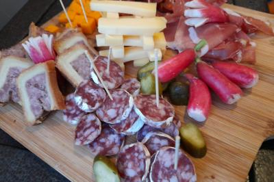 Buffet de salades avec légumes frais, noix, pain tranché et condiments, présenté en extérieur sur une table.