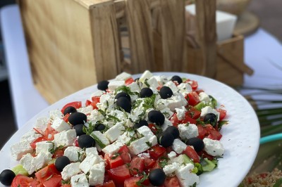 Un food truck bleu avec trois personnes souriantes en tablier devant un comptoir en bois.