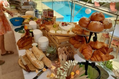 Un food truck bleu avec trois personnes souriantes en tablier devant un comptoir en bois.