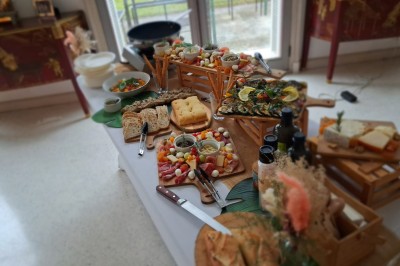 Un food truck bleu avec trois personnes souriantes en tablier devant un comptoir en bois.