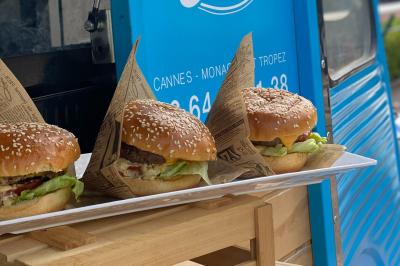 Buffet de salades avec légumes frais, noix, pain tranché et condiments, présenté en extérieur sur une table.