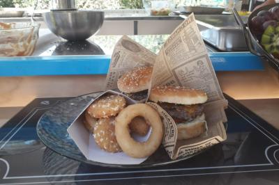 Buffet de salades avec légumes frais, noix, pain tranché et condiments, présenté en extérieur sur une table.