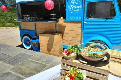 Buffet de salades avec légumes frais, noix, pain tranché et condiments, présenté en extérieur sur une table.