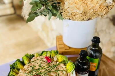 Camion-restaurant bleu vintage devant une concession Mercedes-Benz, avec tables et chaises disposées en terrasse.