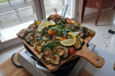 Camion-restaurant bleu vintage devant une concession Mercedes-Benz, avec tables et chaises disposées en terrasse.