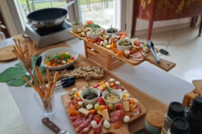 Camion-restaurant bleu vintage devant une concession Mercedes-Benz, avec tables et chaises disposées en terrasse.