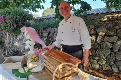 Camion-restaurant bleu vintage devant une concession Mercedes-Benz, avec tables et chaises disposées en terrasse.