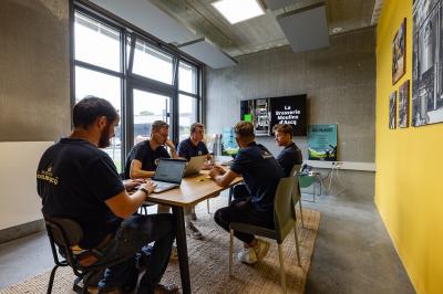 Une personne sert un plateau de dégustation avec trois verres de bière sur un comptoir de bar.
