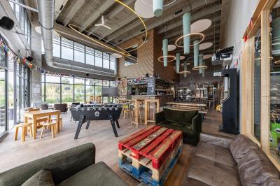 Une personne sert un plateau de dégustation avec trois verres de bière sur un comptoir de bar.