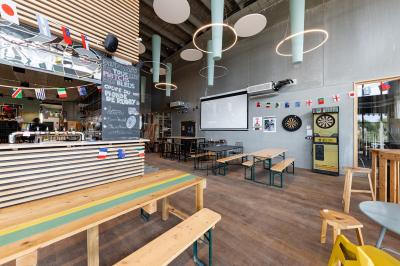 Bar décoré avec des drapeaux internationaux, des bouteilles alignées sur des étagères et des verres suspendus au plafond.