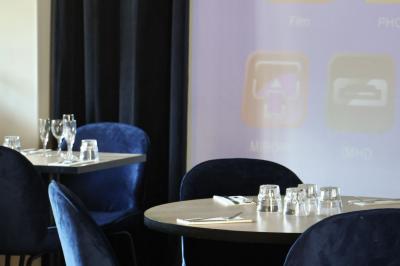 Quatre bouteilles de vin rouge exposées sur un présentoir en bois éclairé, avec une caisse de vin en dessous.