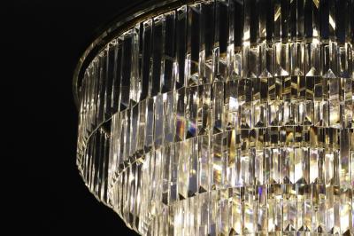 Quatre bouteilles de vin rouge exposées sur un présentoir en bois éclairé, avec une caisse de vin en dessous.