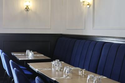 Quatre bouteilles de vin rouge exposées sur un présentoir en bois éclairé, avec une caisse de vin en dessous.