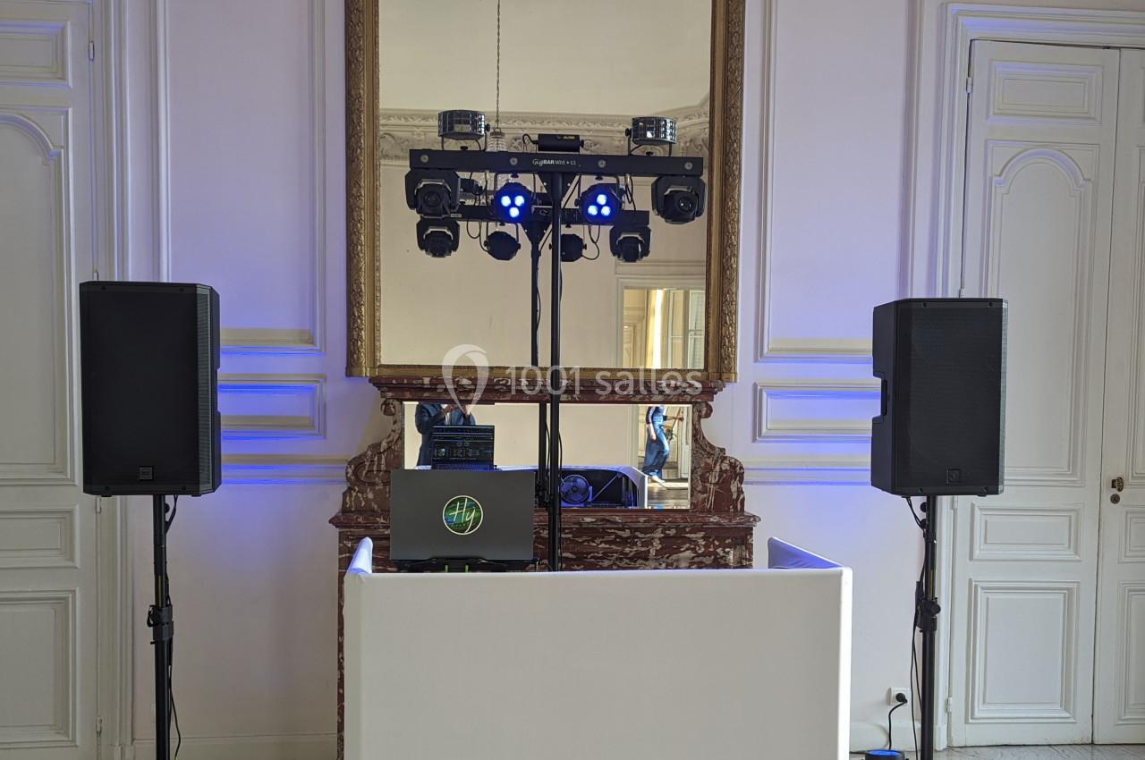 Installation de matériel de sonorisation et d'éclairage devant une cheminée avec miroir dans une pièce élégante.