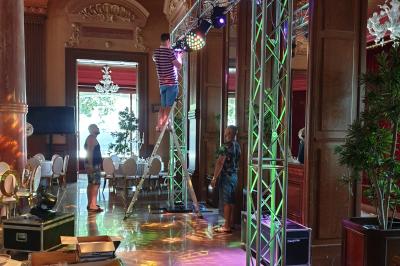 Salle de réception décorée avec des tables élégantes, nappes blanches, centres de table lumineux et plumes blanches.