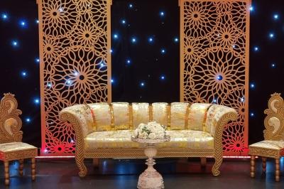 Salle de réception décorée avec des tables élégantes, nappes blanches, centres de table lumineux et plumes blanches.