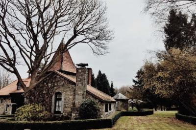 Chambre avec lit double, baignoire îlot, parquet, carrelage hexagonal et échelle porte-serviettes.