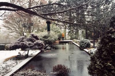Chambre avec lit double, baignoire îlot, parquet, carrelage hexagonal et échelle porte-serviettes.